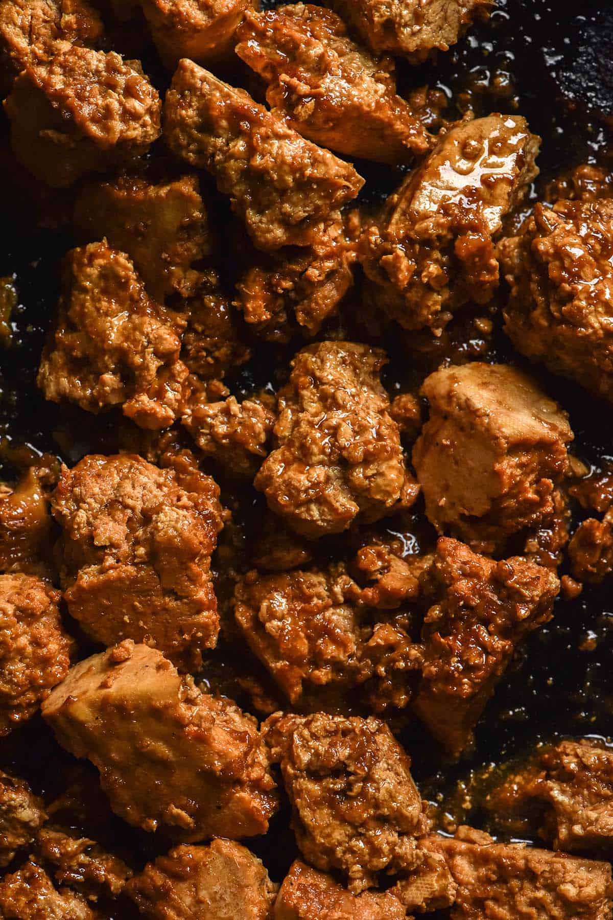 An aerial image of marinated tofu in a cast iron skillet