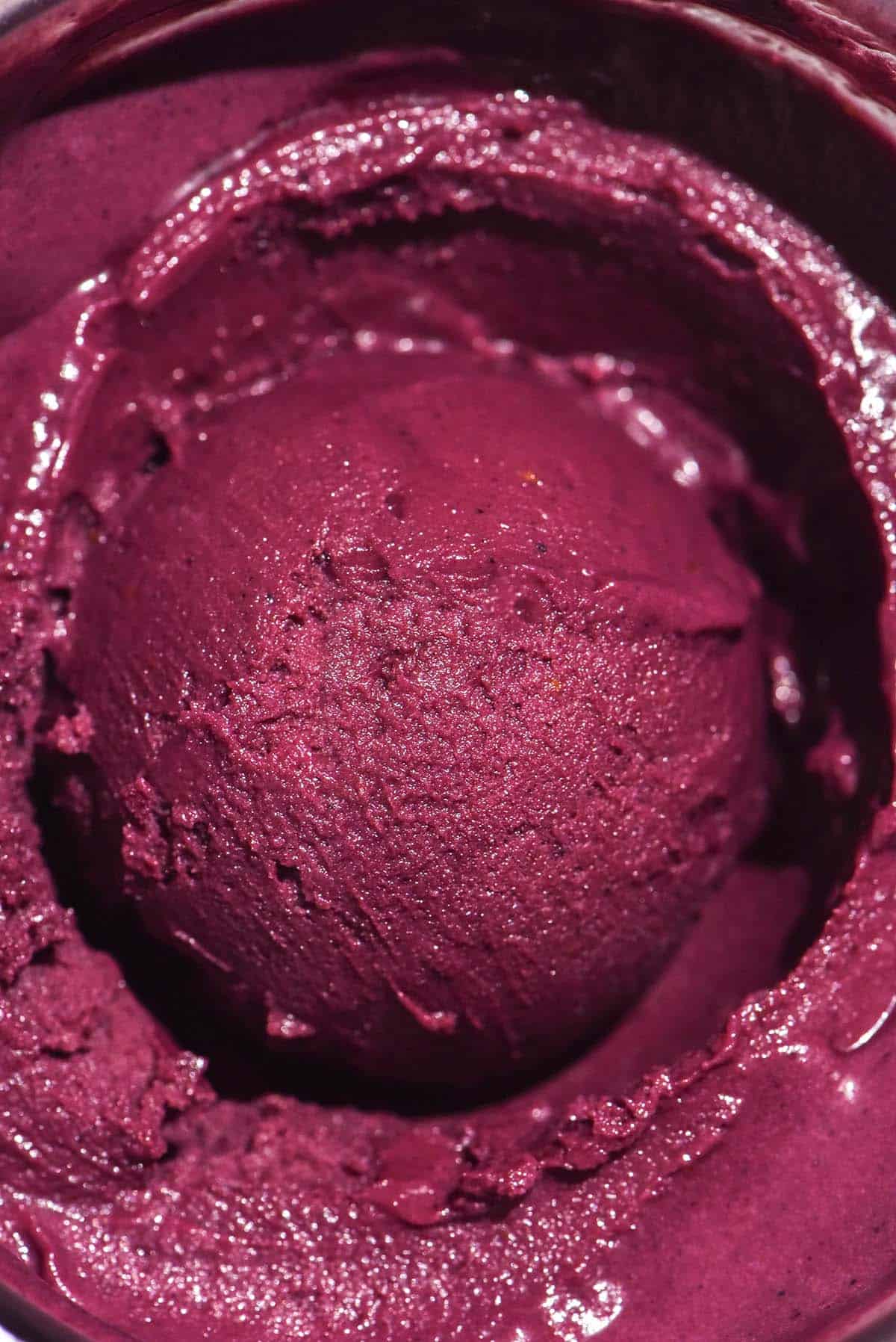 An aerial macro image of a tub of Ninja Creami açai that has a scoop of açai in the centre