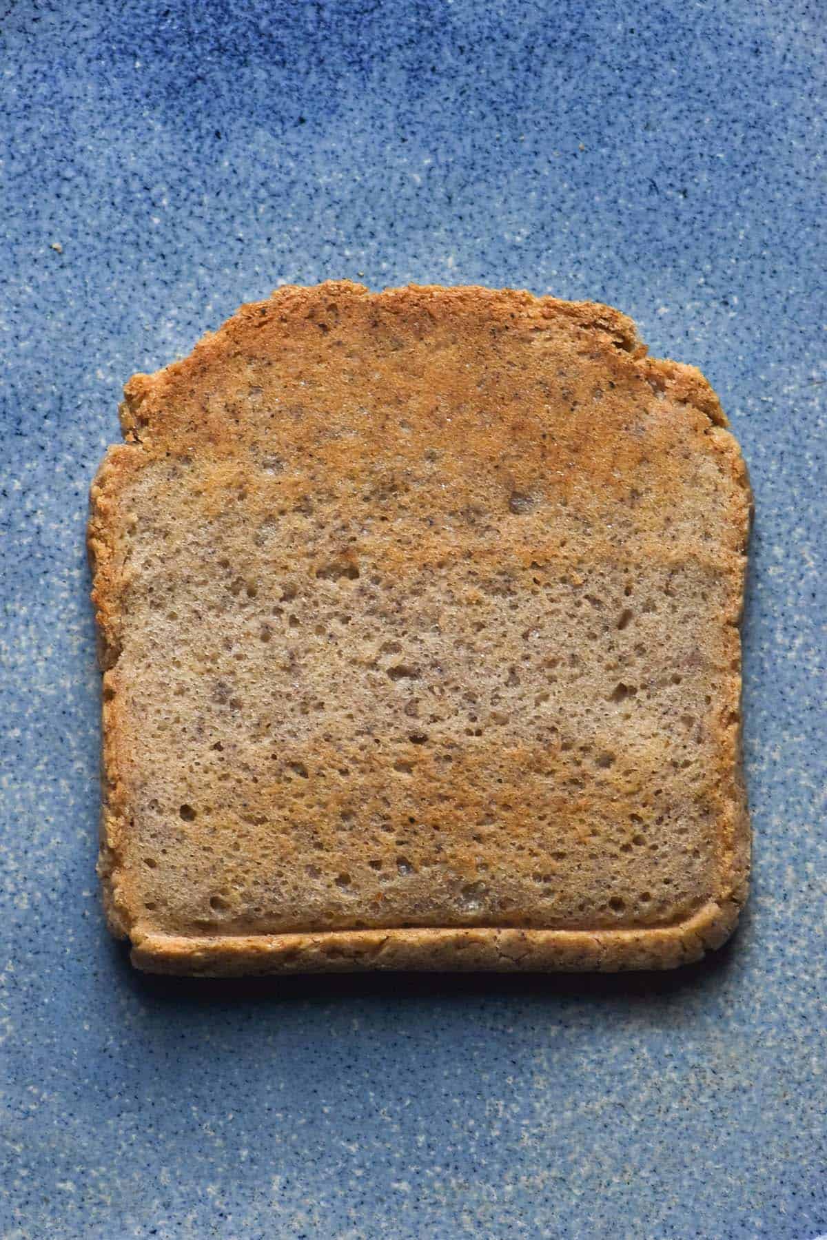 An aerial image of a slice of low histamine toast atop a bright blue ceramic plate