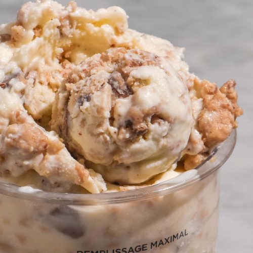 A macro close up image of a tub of Ninja Creami cookie dough ice cream on a white marble table