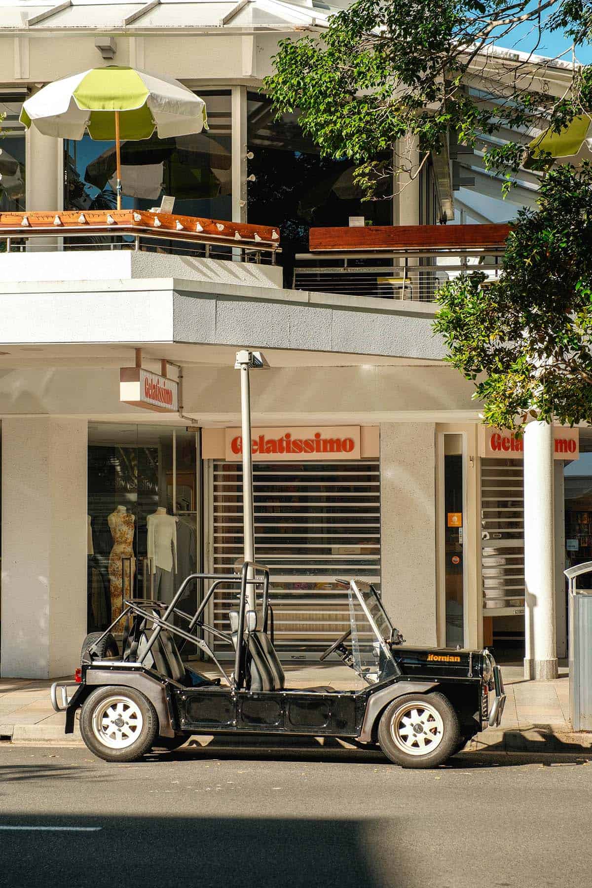 A streetscape image of a mini moke on Hastings Street, Noosa