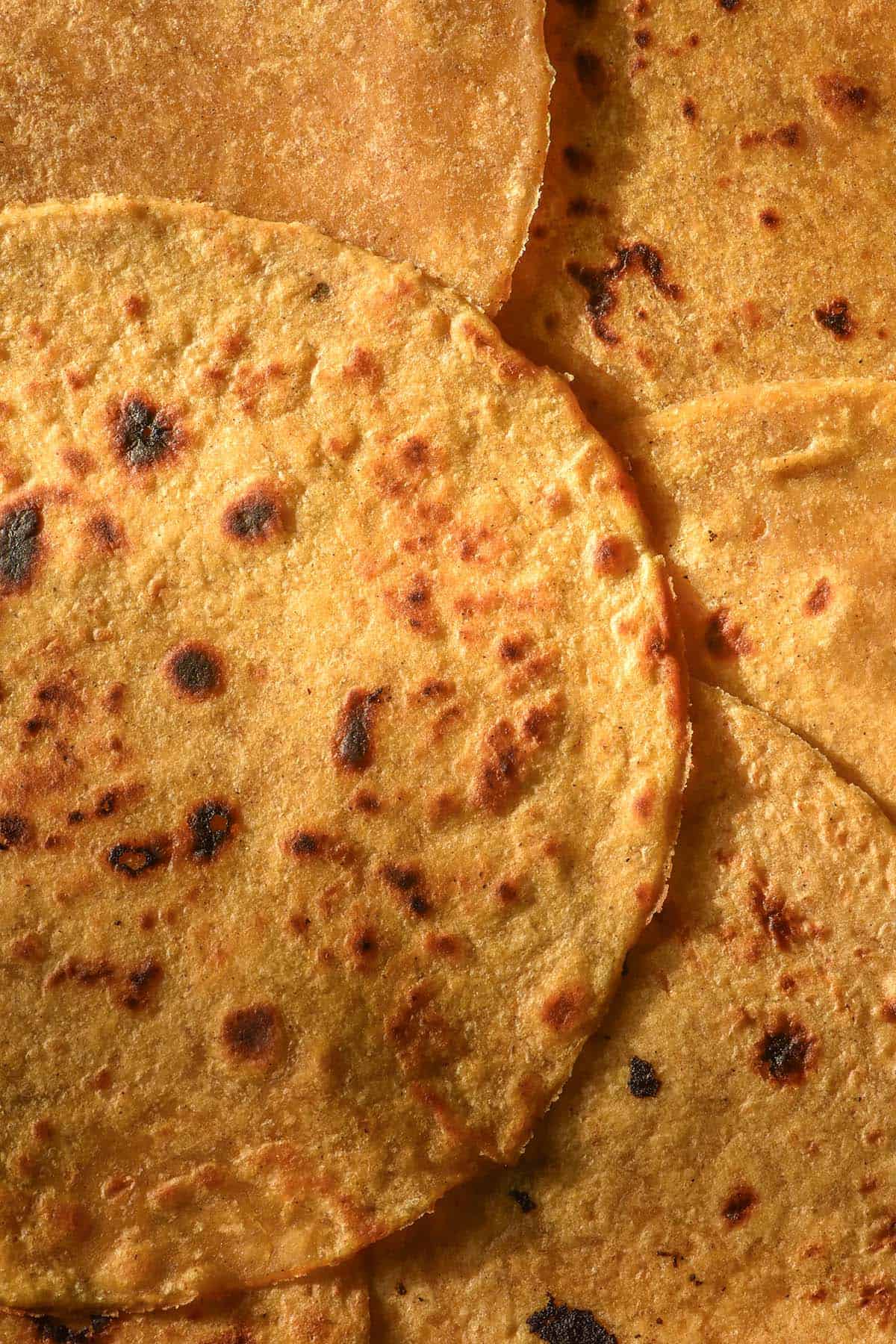 A close up macro image of sweet potato tortillas casually piled on top of each other