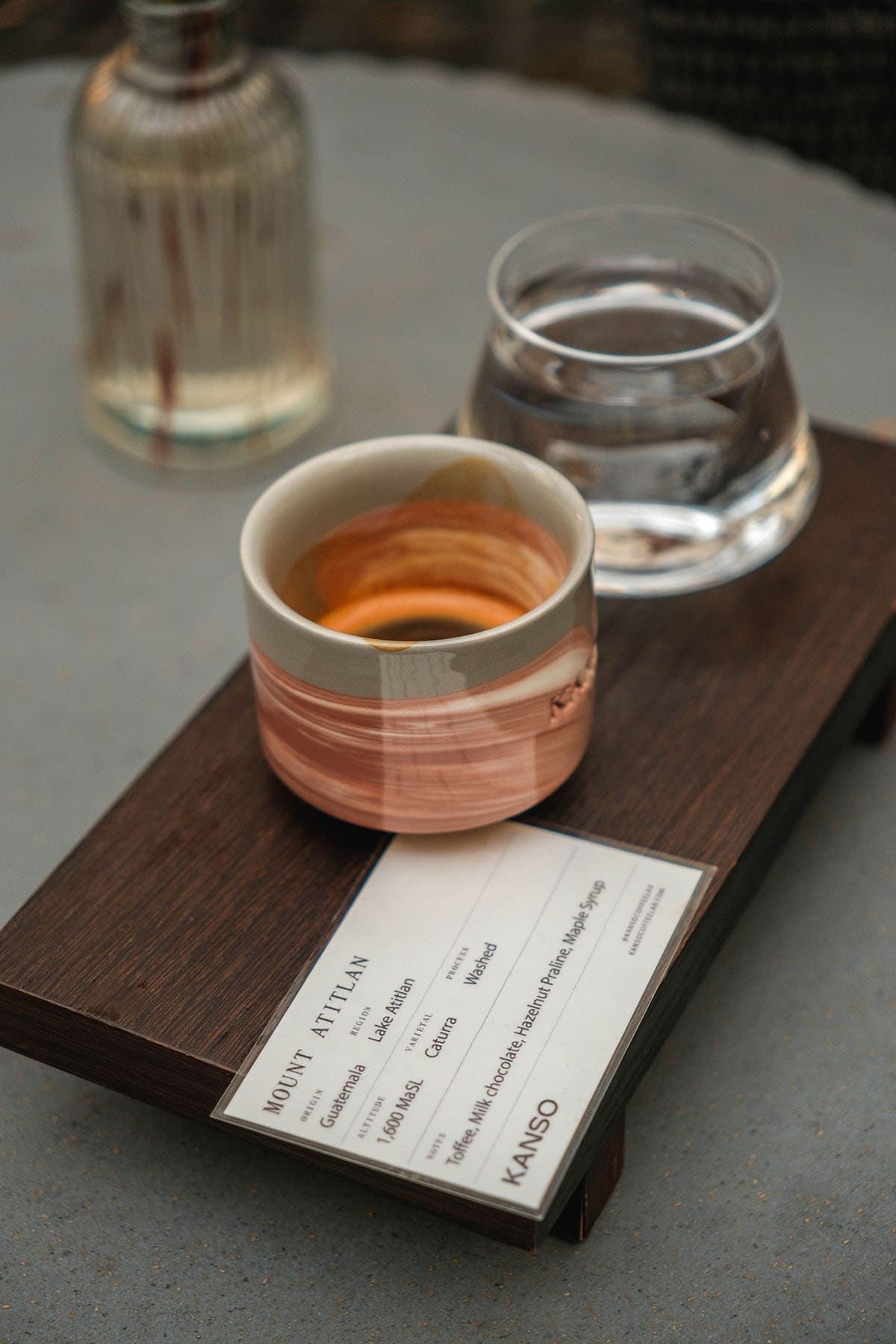 An image of an espresso in a coloured ceramic cup on a wooden board from Kanso Coffee Labs in Munich