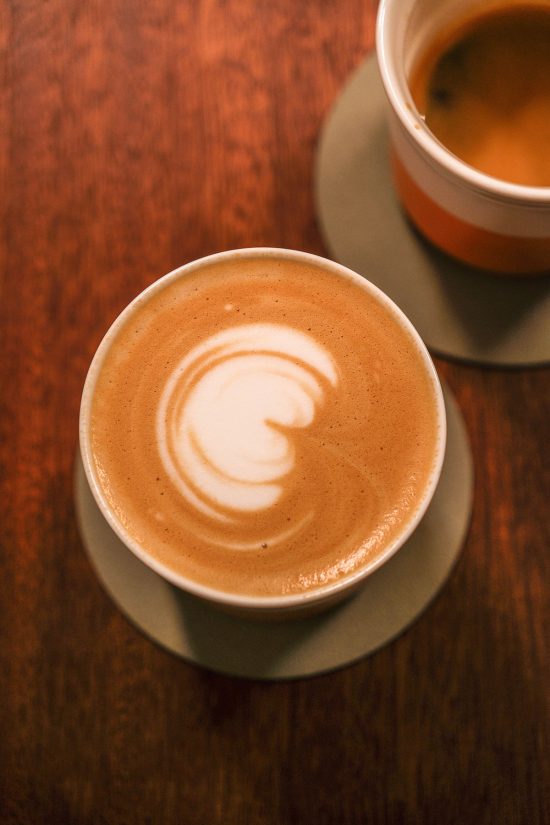 An aerial image of a latte and an espresso on a wooden table at April Coffee in Copenhagen