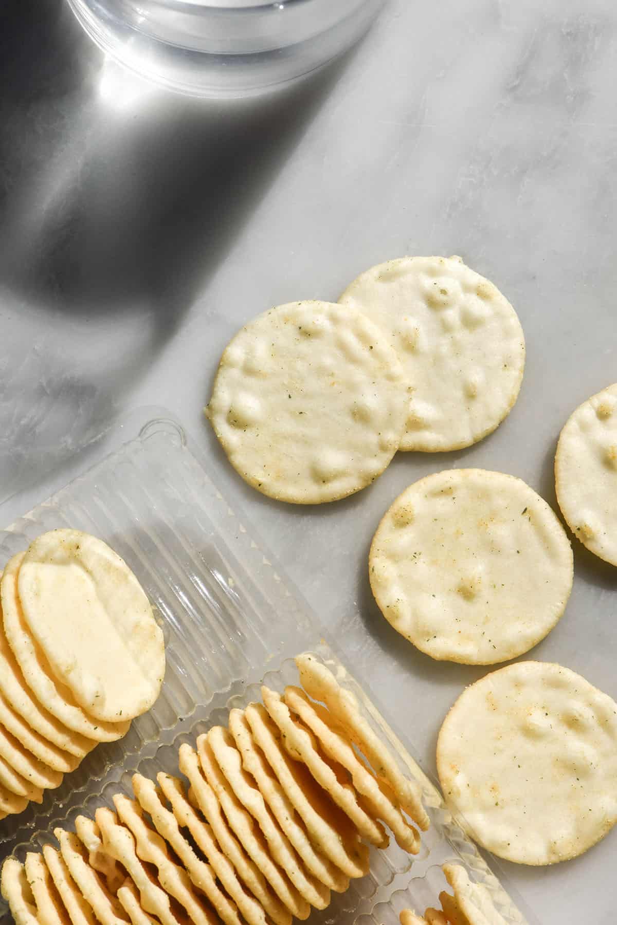 An aerial image of rice crackers on a white marble table in bright sunlight