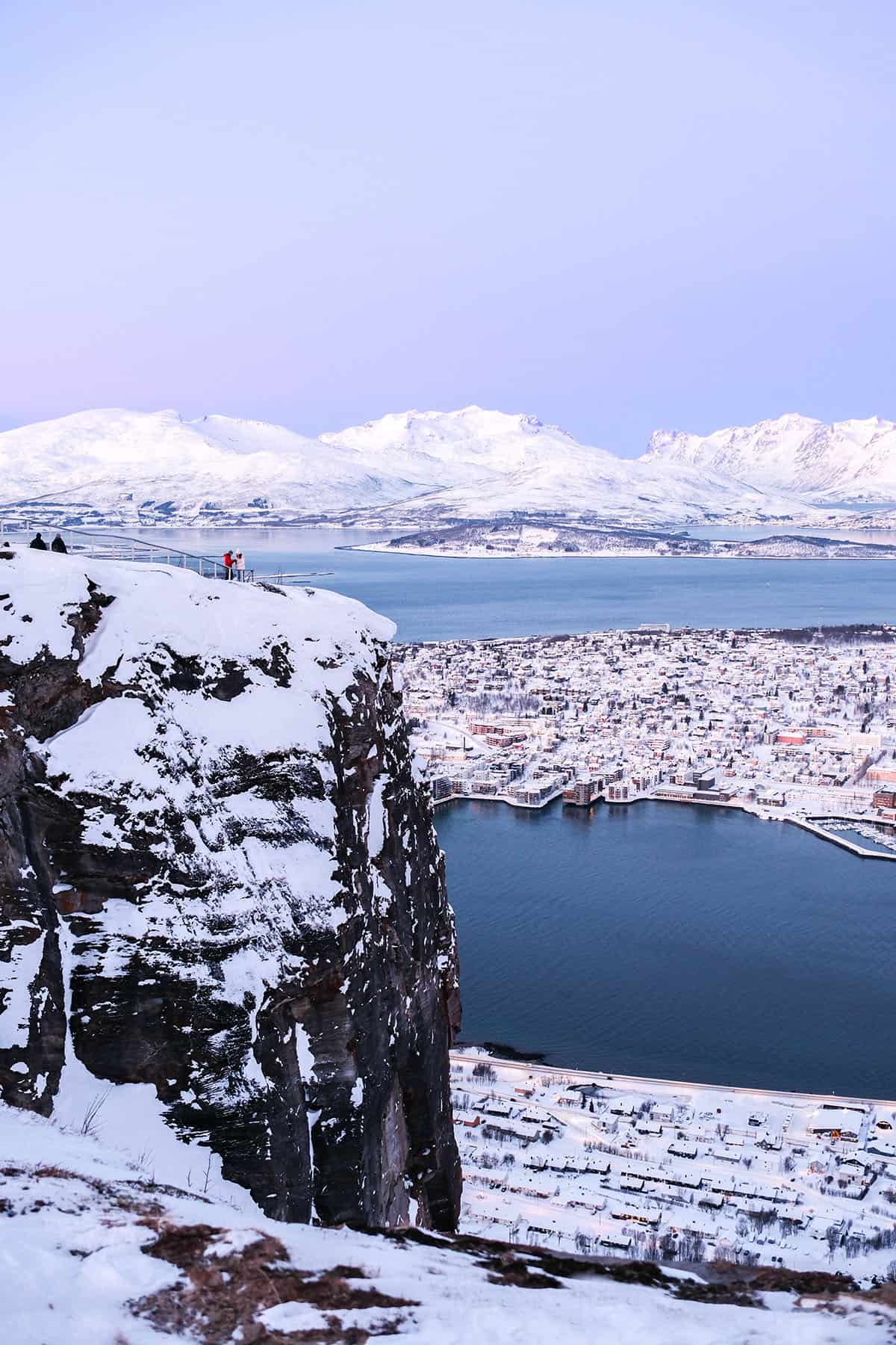 An image of the view from Fjellheisen, Norway over winter with a pink sunrise in the background