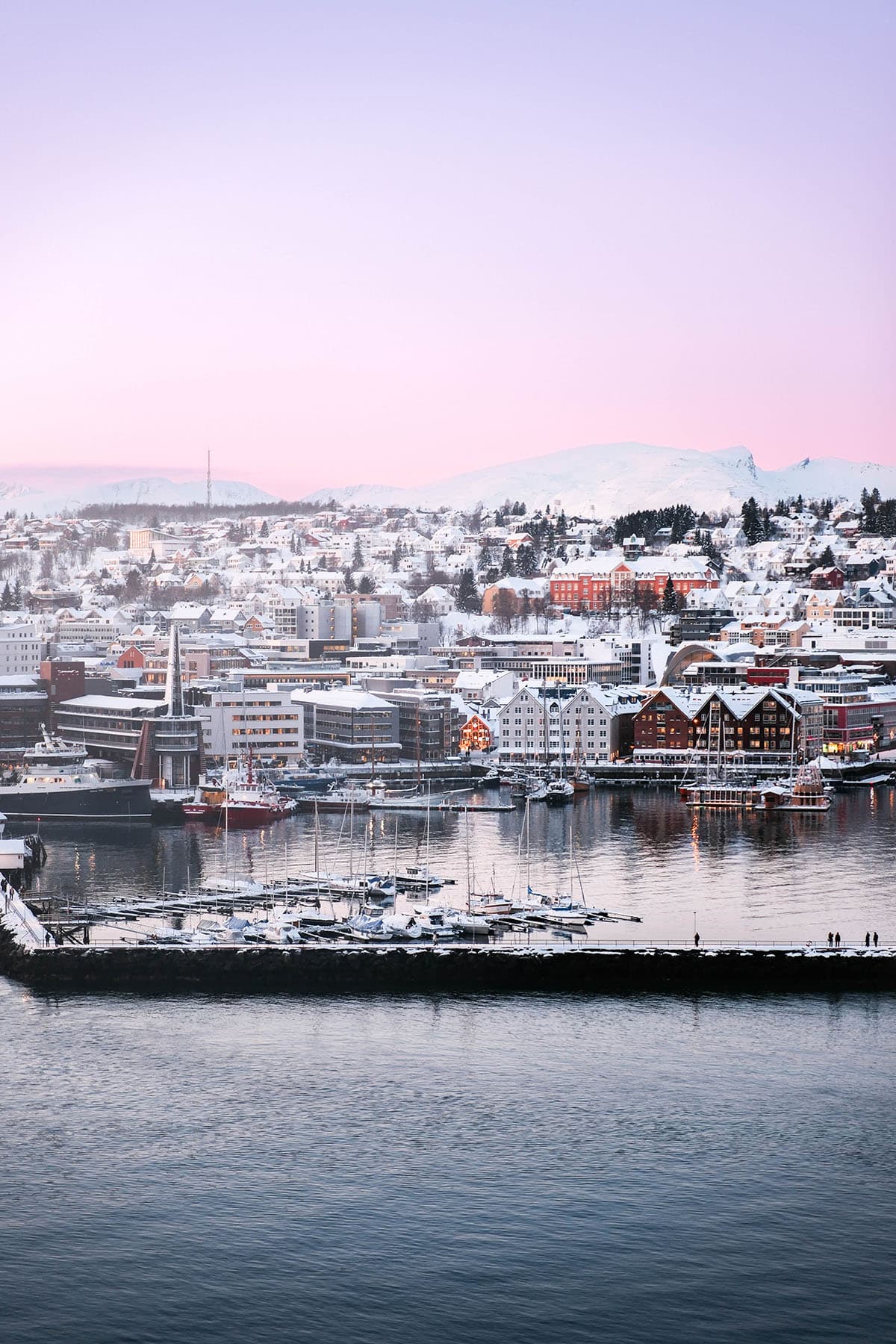 An image of Tromso in winter as seen from the bridge on a wintery afternoon with a pink sunset