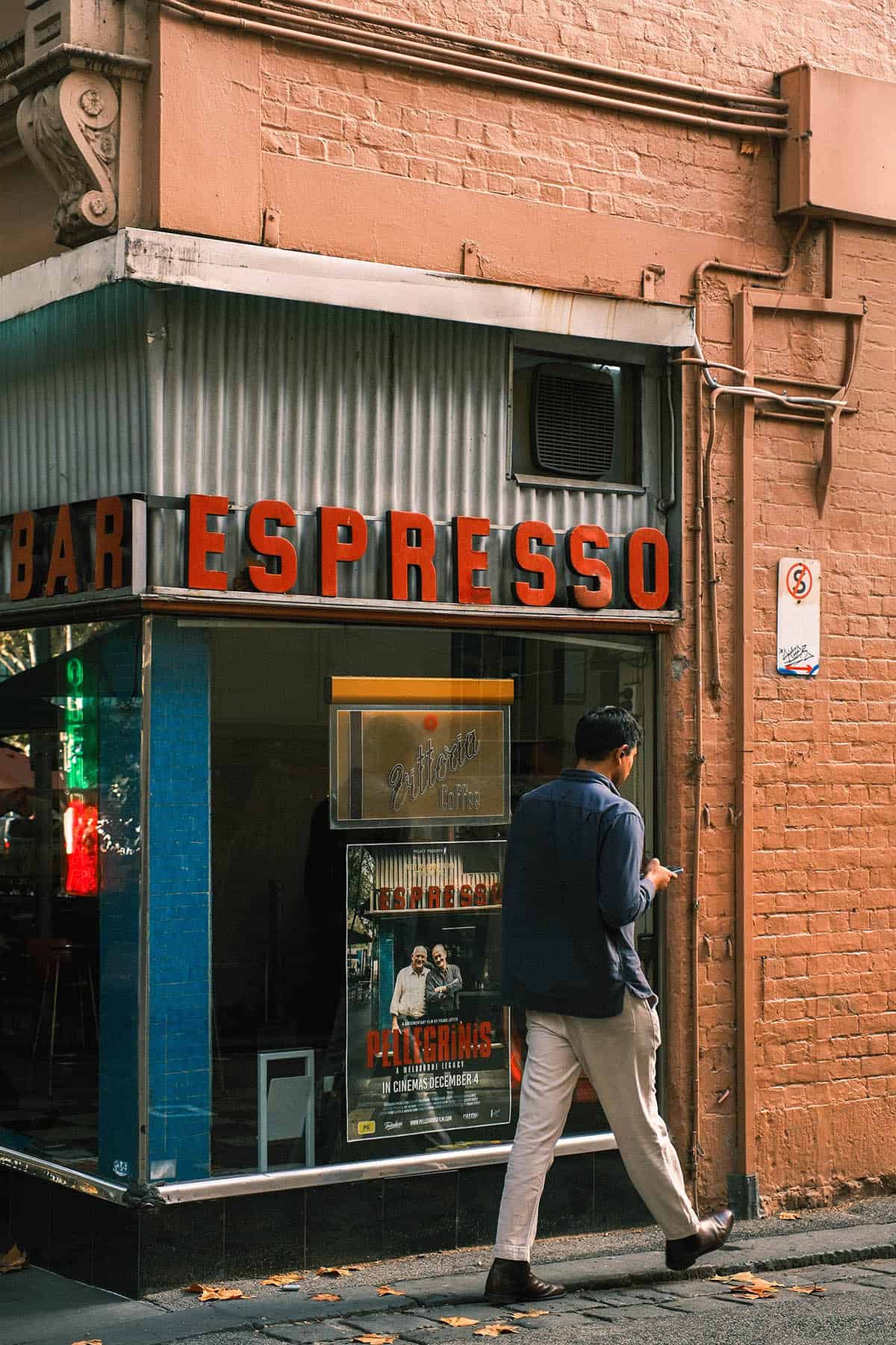 An image of a man walking past Pellegrinis coffee shop In Melbourne CBD