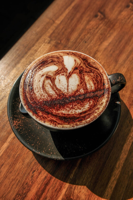 An aerial image of a cappuccino on a wood grain table in McCrae, Mornington Peninsula