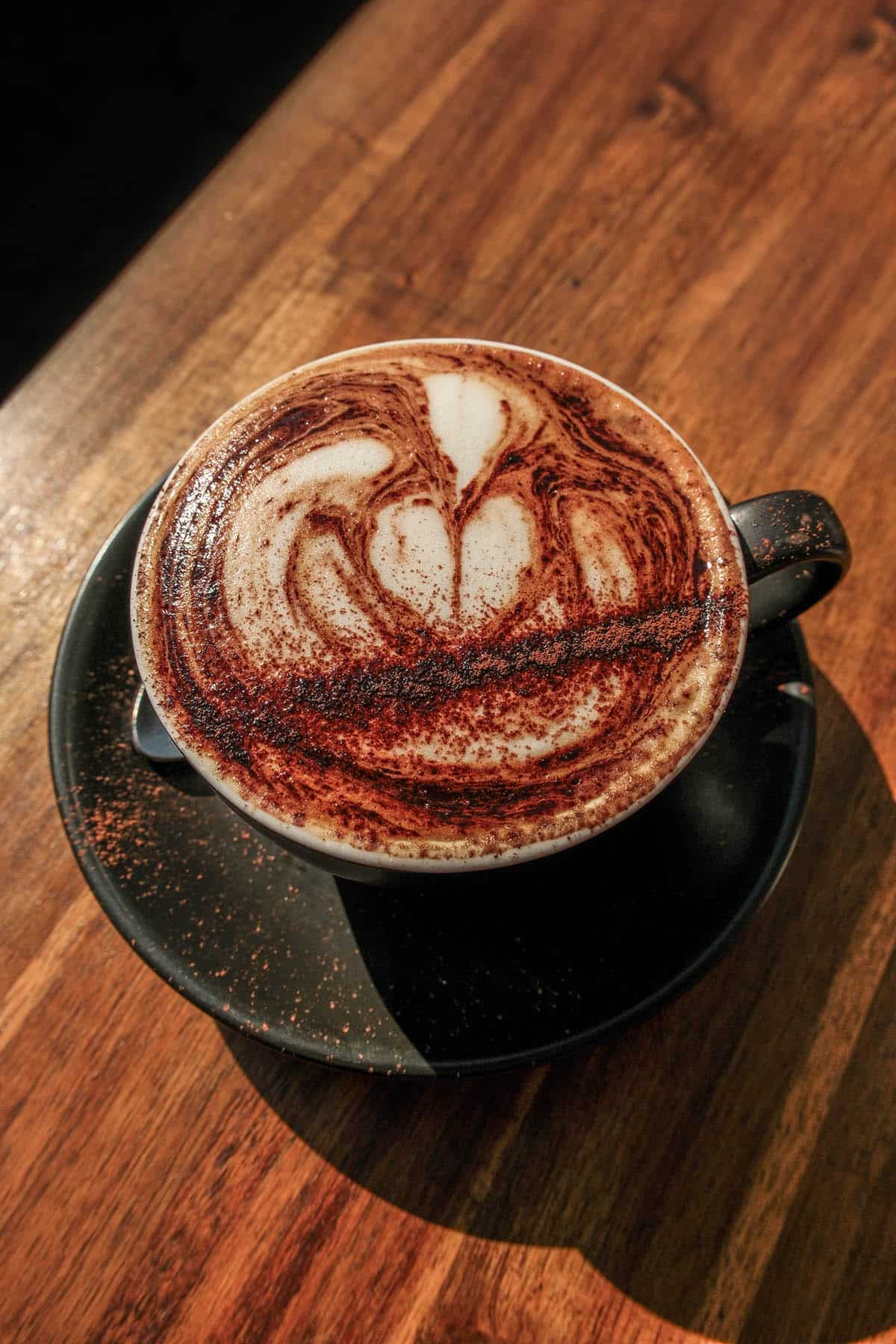 An aerial image of a cappuccino on a wood grain table in McCrae, Mornington Peninsula