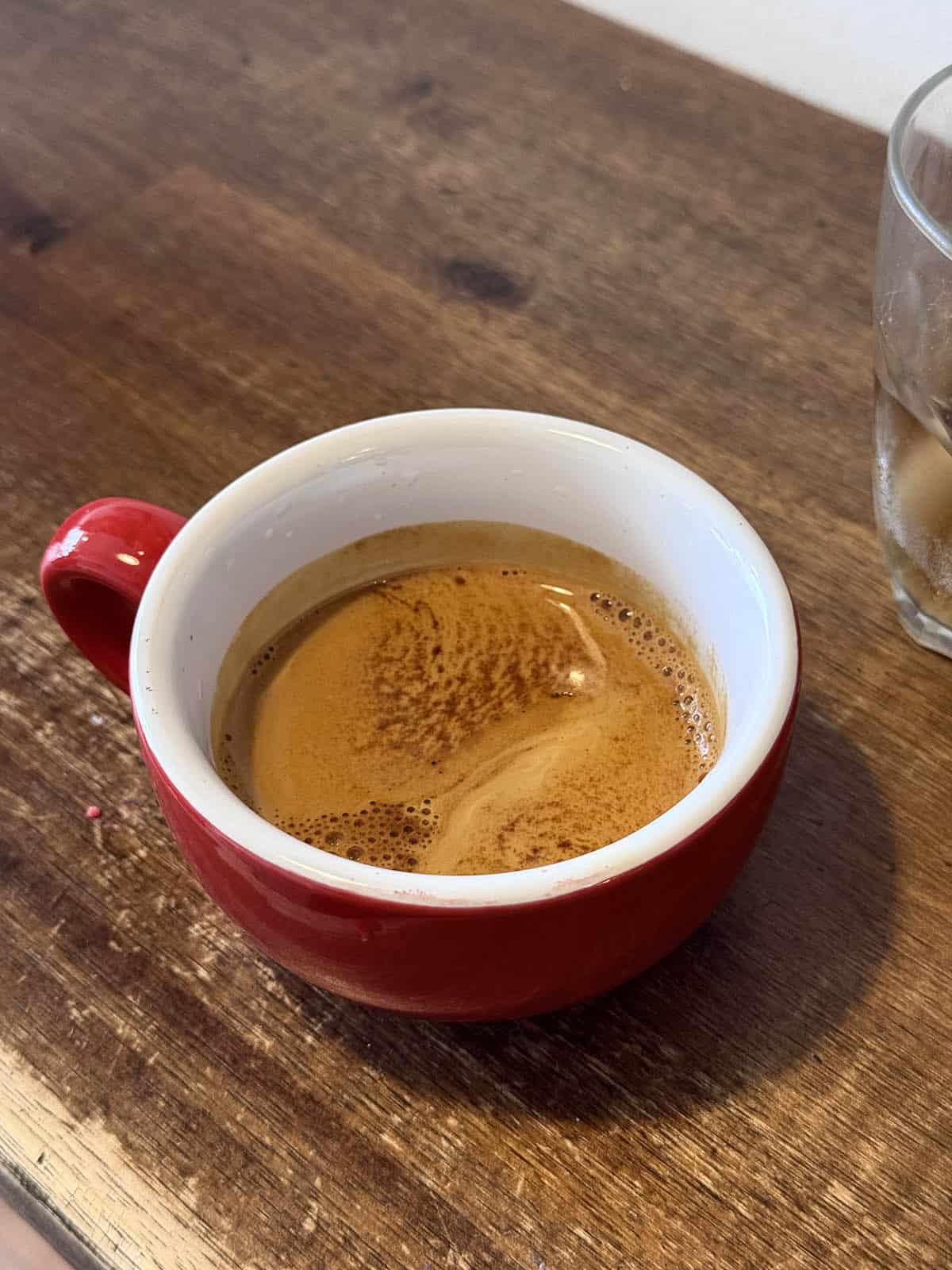 An image of an espresso from Velos Mazeh Musette in Mount Martha atop a wooden table