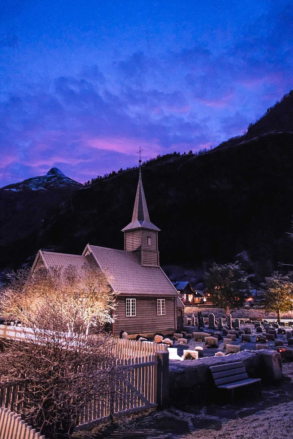 An image of Flåm church in Norway on a snowy sunset afternoon