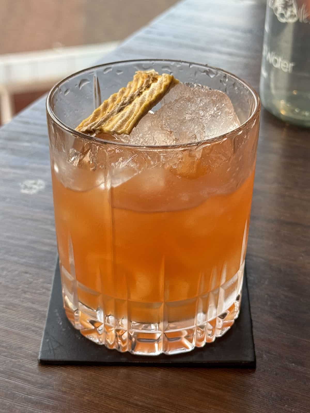 An image of a cocktail with a plantain chip garnish at Hero Bar in Nairobi