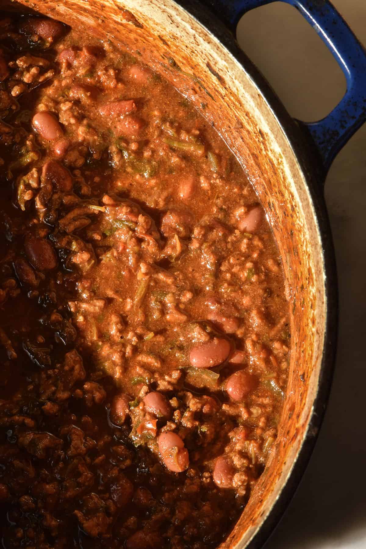 An aerial closeup of a pot of low FODMAP chilli con carne in contrasting sunlight