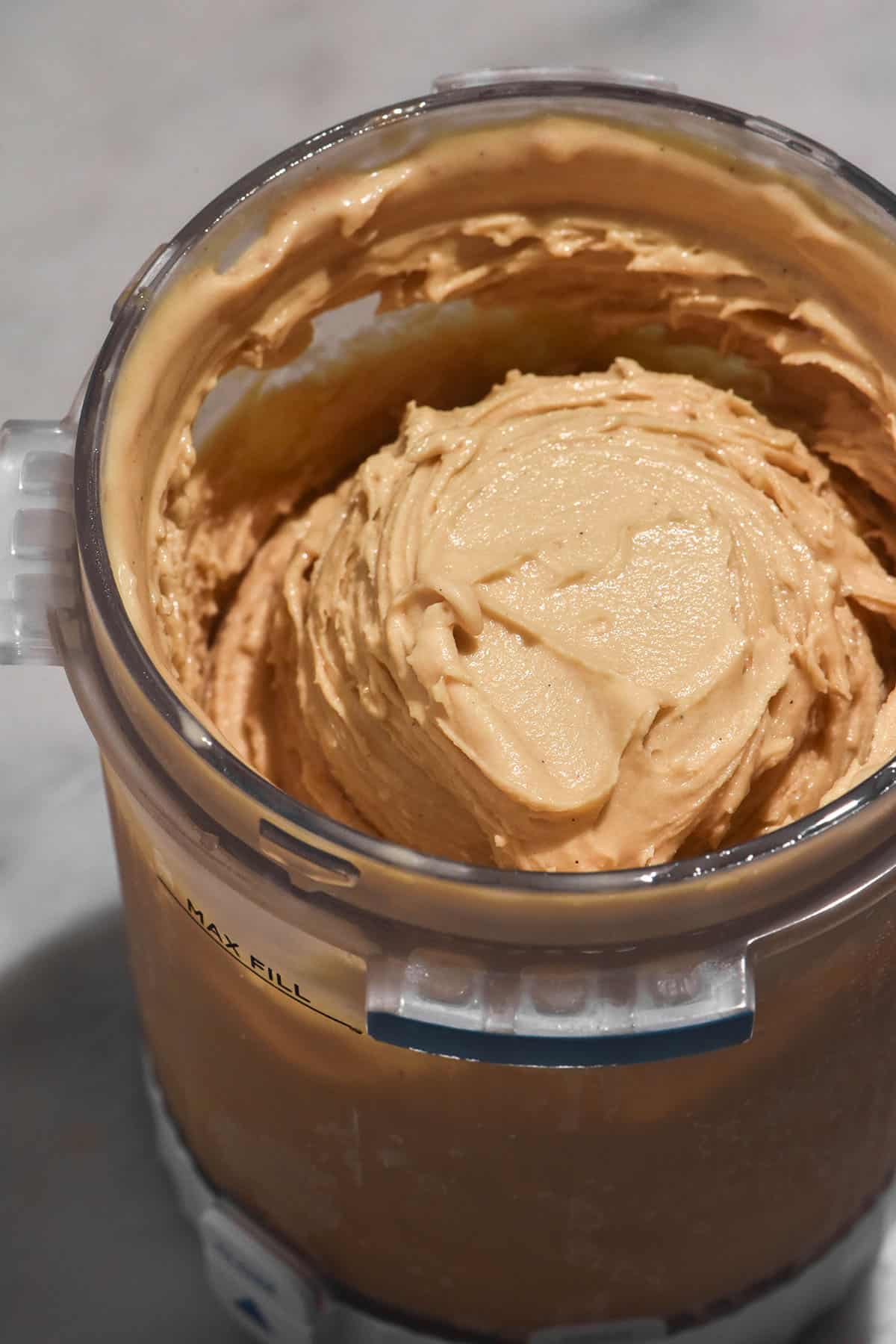 A close up aerial image of a tub of Ninja Swirl coffee ice cream on a white marble table