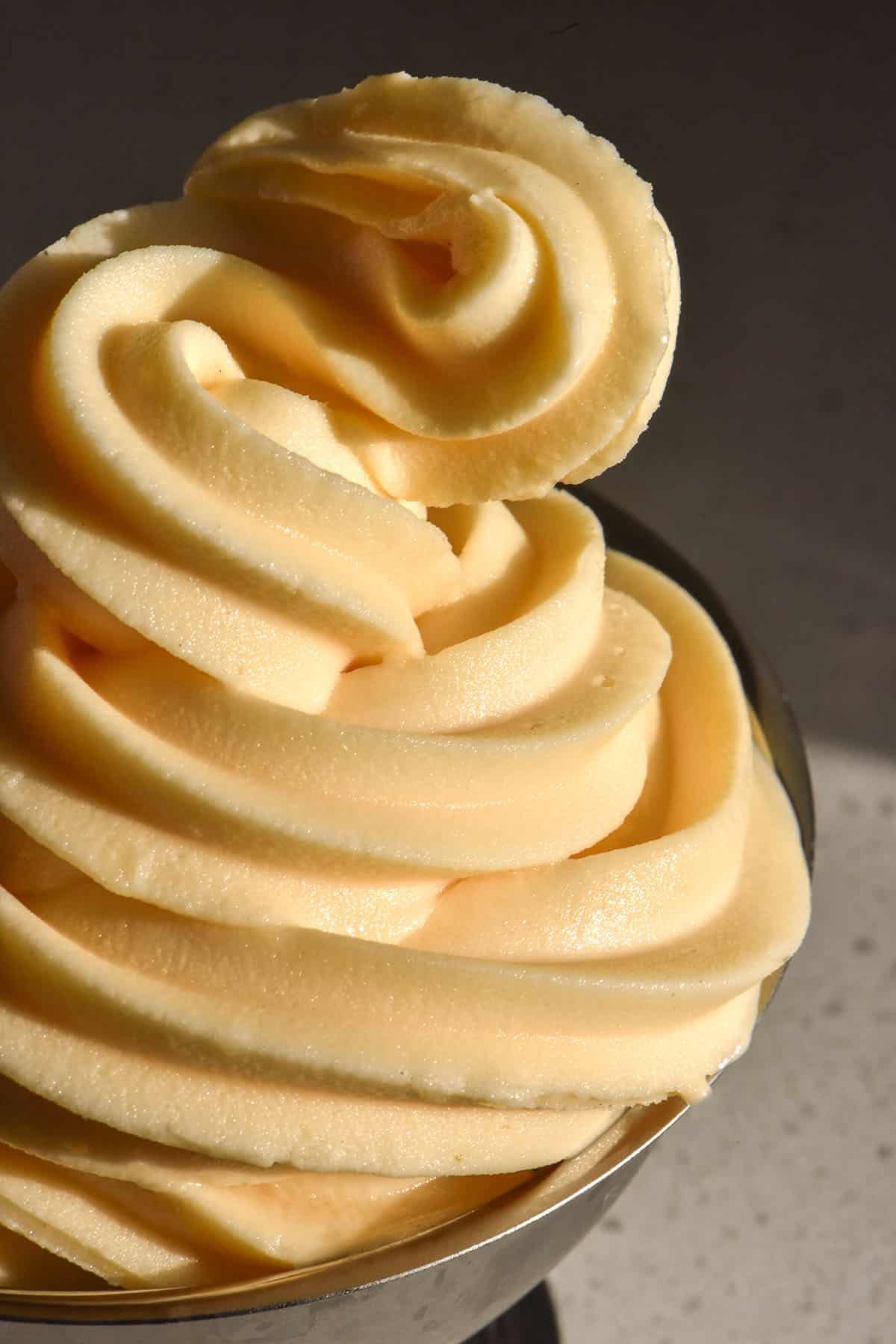 A close up image of Ninja Swirl custard soft serve swirled in a silver dessert coupe in contrasting light