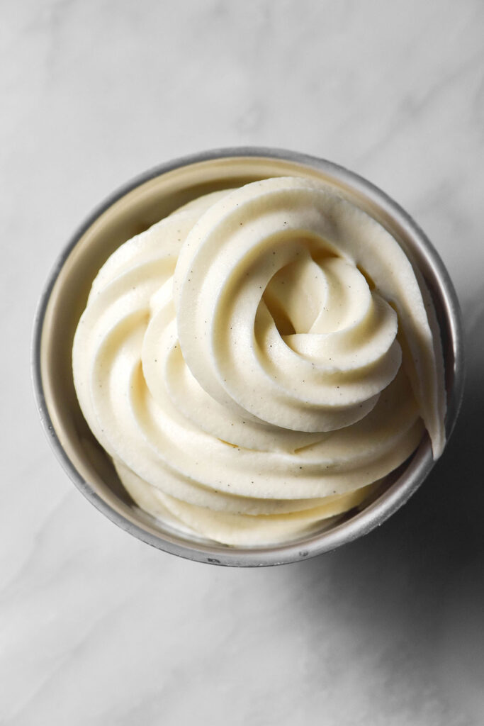 An aerial image of Ninja Swirl vanilla soft serve in a dessert coupe on a white marble table