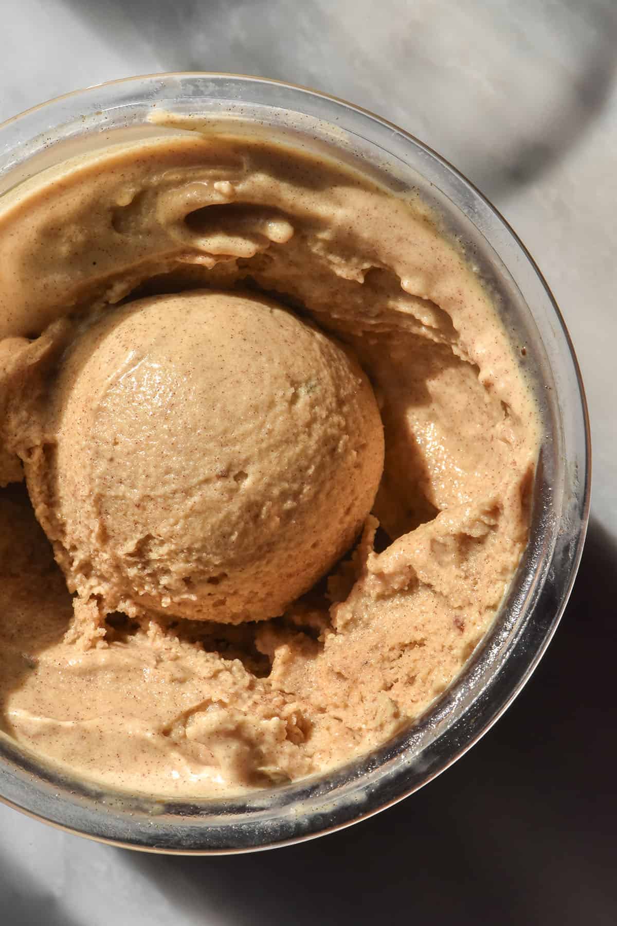 An aerial macro image of a tub of Ninja Creami vegan sticky date ice cream