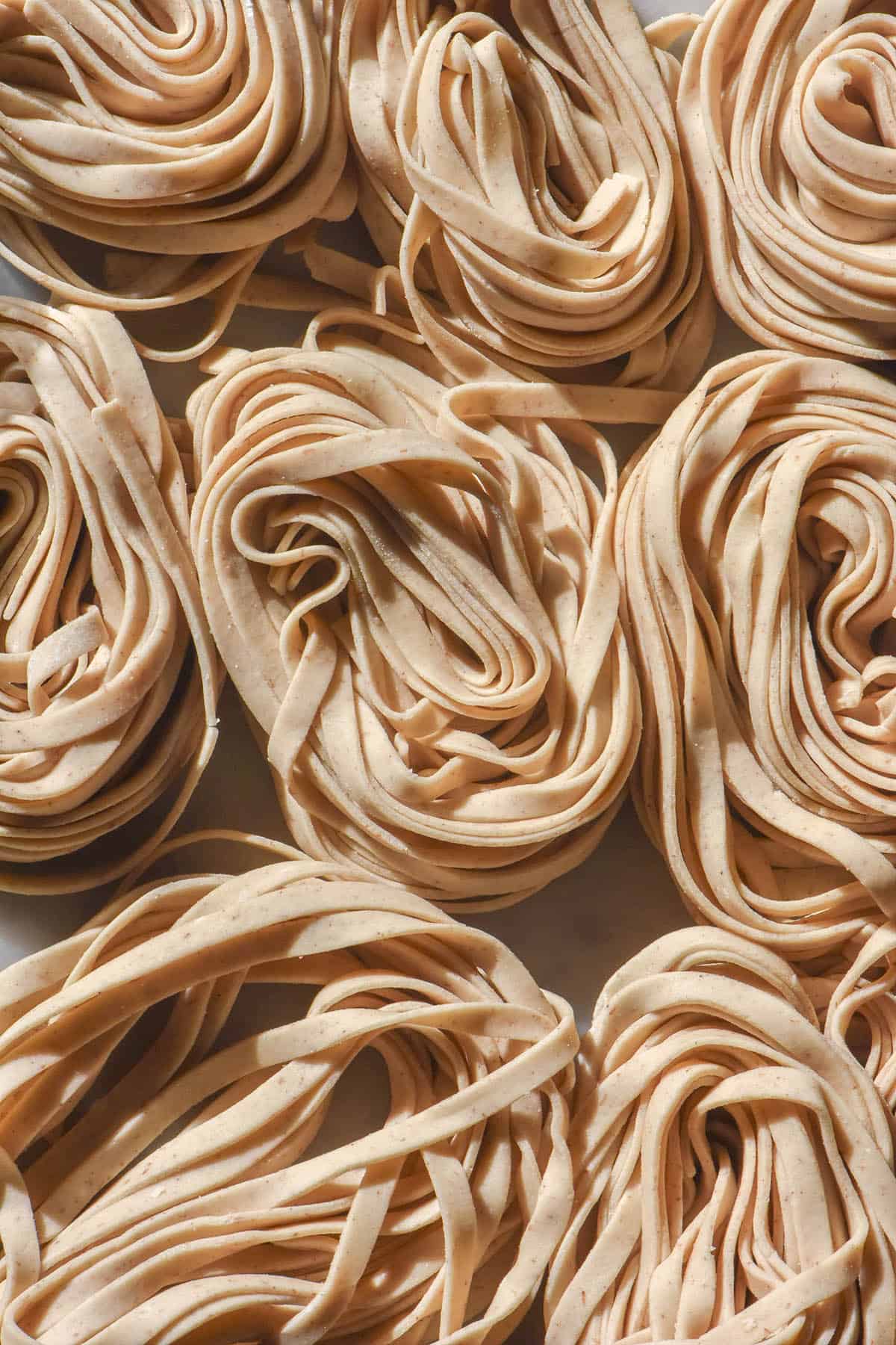 An aerial image of gluten free sourdough discard pasta twirled into nests